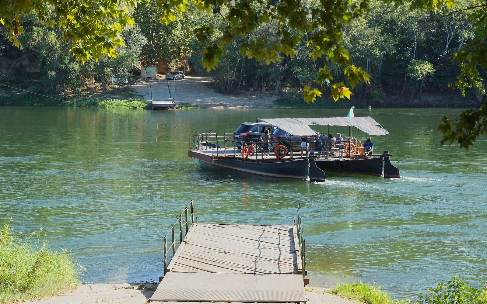 De traditionele kabelpont van Miravet steekt de Ebro over met een auto aan boord