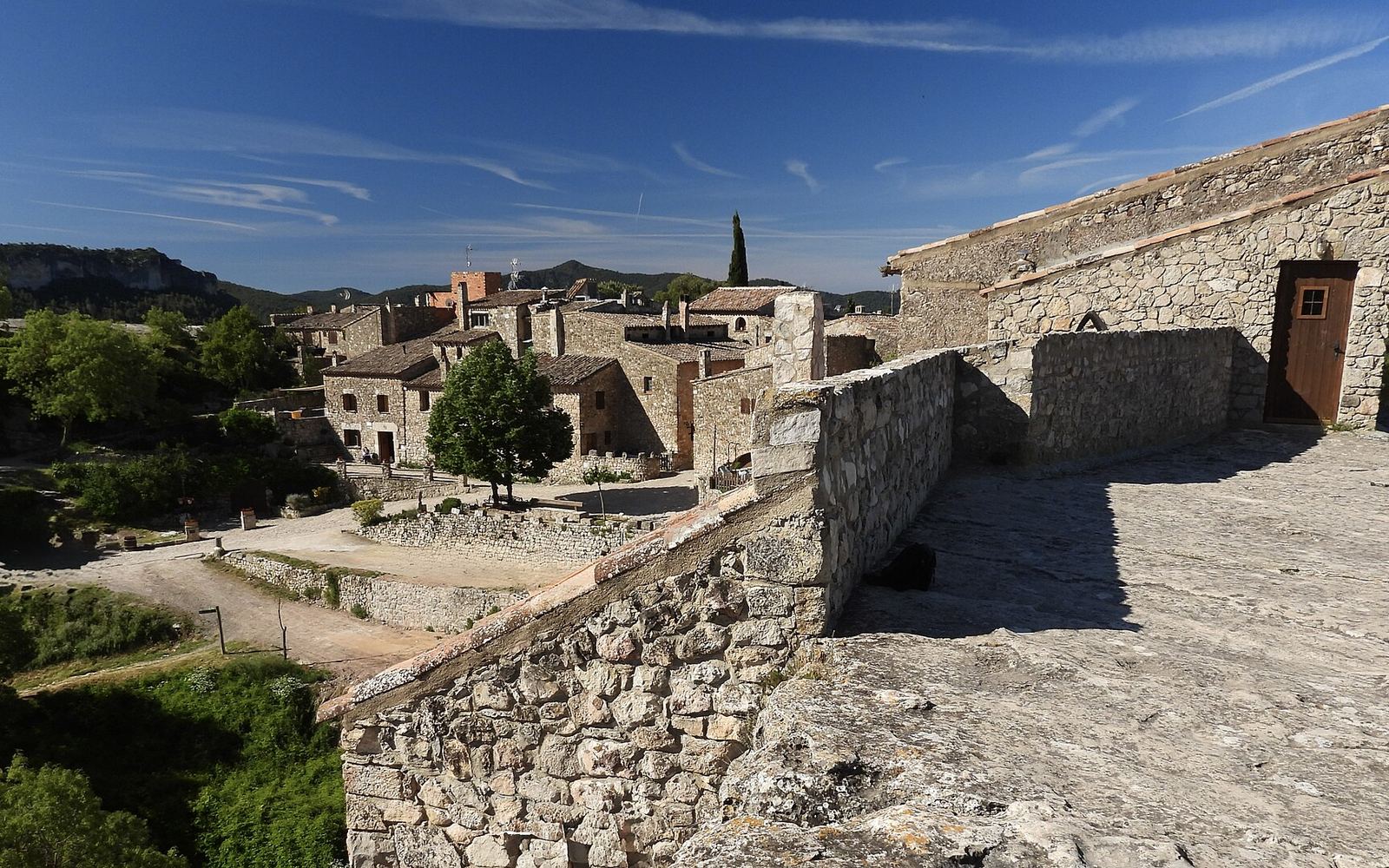 Het stenen dorp Porrera in een groen dal tussen de wijngaarden van de Priorat