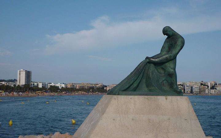 Het brede zandstrand Platja de Llevant in Salou met palmbomen langs de boulevard